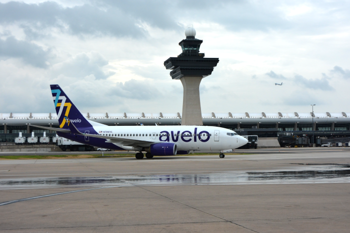 An Avelo airplane sits on a rainy runway at Dulles International Airport.